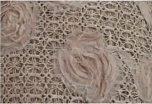 Acercamiento de tul nude con rosas bordadas en relieve