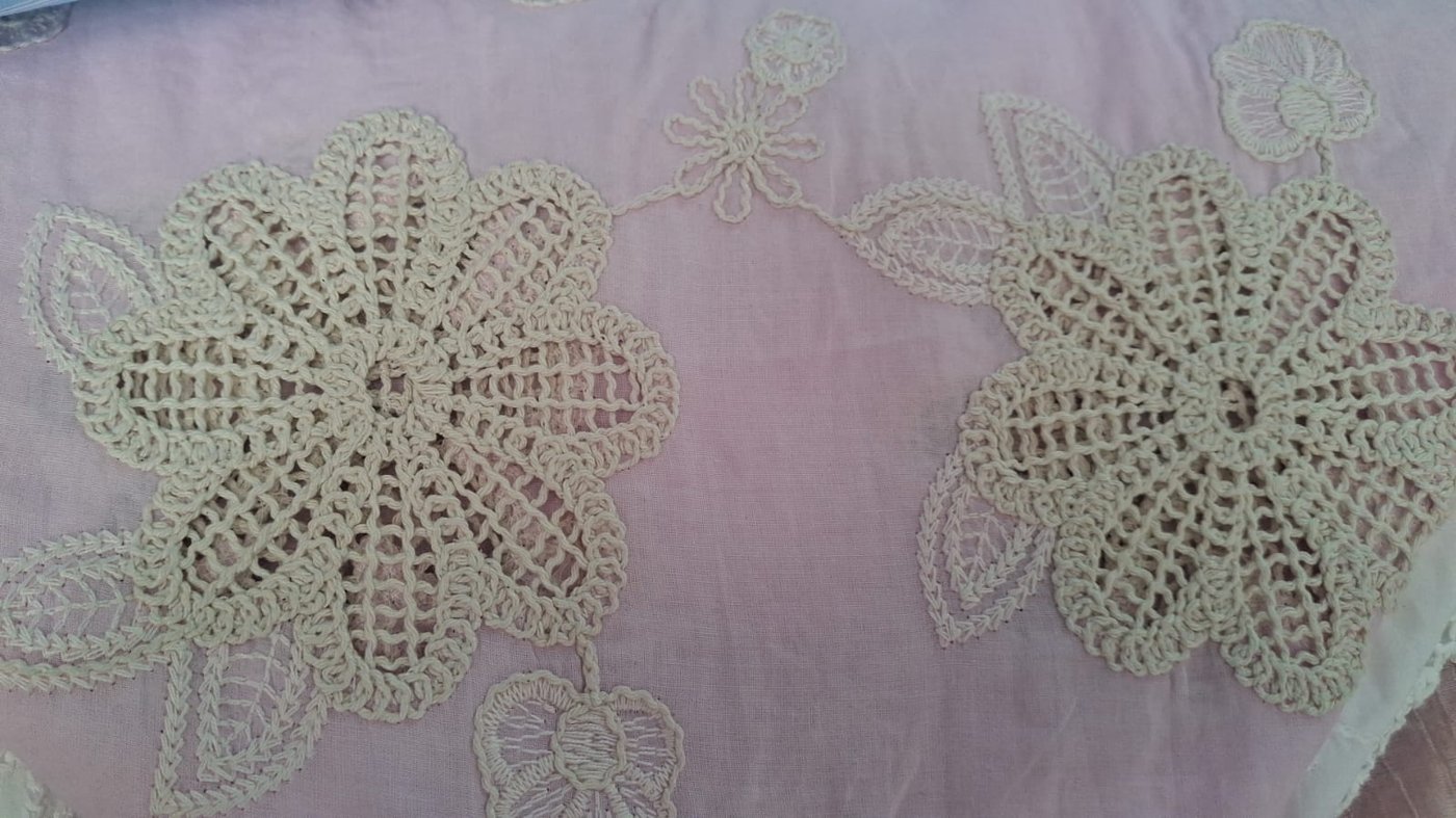 Tela rosa tenue con flores blancas bordadas