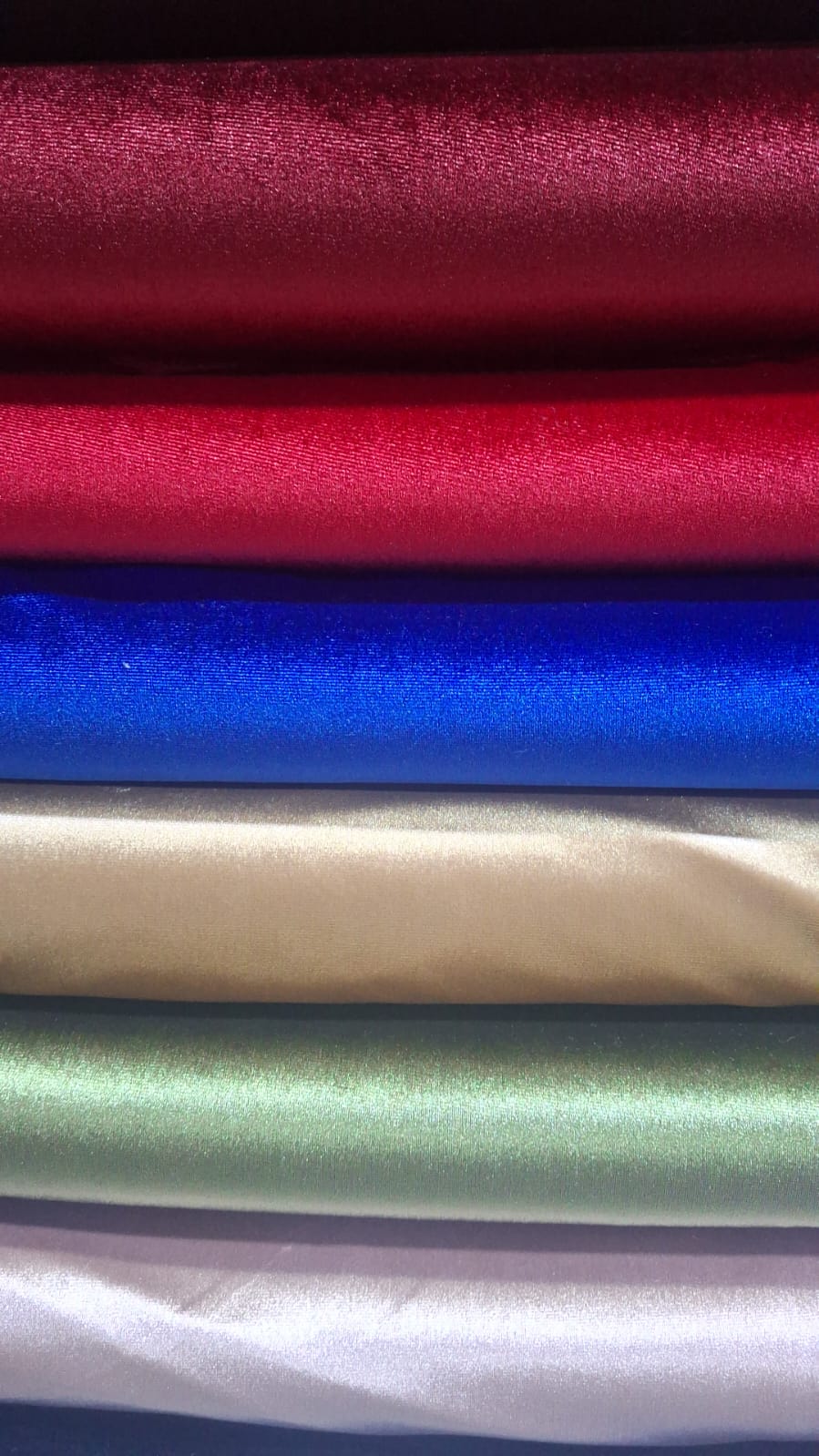 Telas de terciopelo apiladas en vino, rojo, azul, dorado y verde