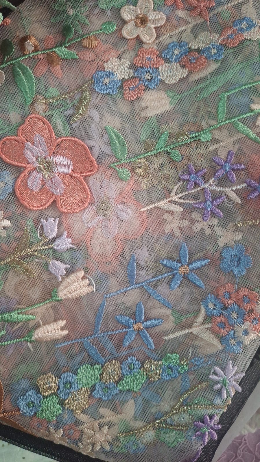 Bordado floral multicolor con flores coral, lavanda y azul sobre tul claro