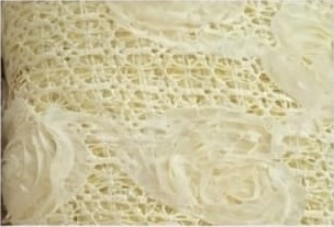 Acercamiento de tul amarillo suave con rosas bordadas en relieve